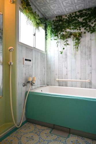 a bath tub in a bathroom with a window at SYMPOSION Locanda in Kamakura
