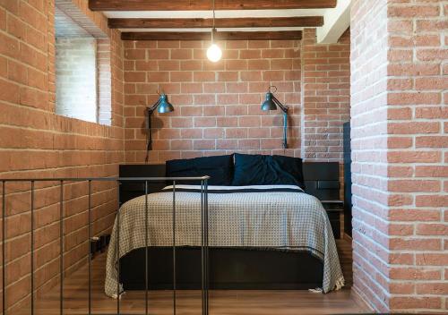 a bedroom with a bed in a brick wall at Casale Gambini in Quattro Castella