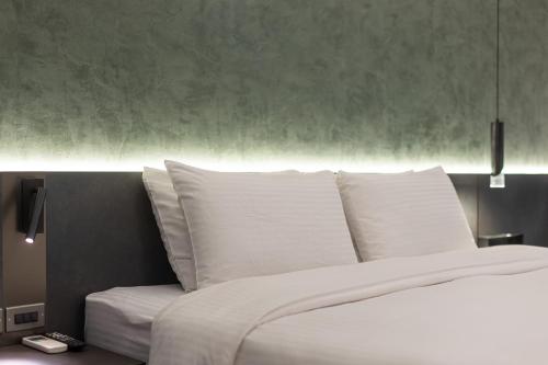 a white bed with white pillows in a bedroom at Green Hotel in Magong