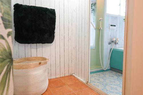 a bathroom with a toilet and a shower and a bucket at SYMPOSION Locanda in Kamakura