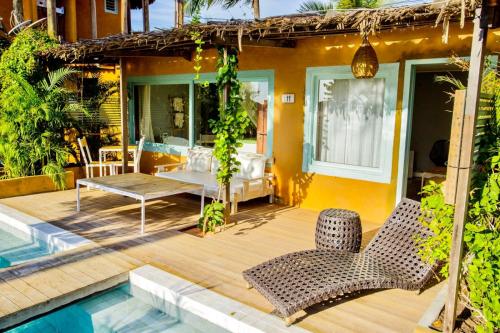 a patio with a table and chairs and a pool at Pousada Mi Secreto in São Miguel do Gostoso