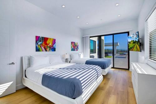 a white bedroom with two beds and a window at An Architectural masterpiece with unparalleled beauty, elegance and amenities in Temecula