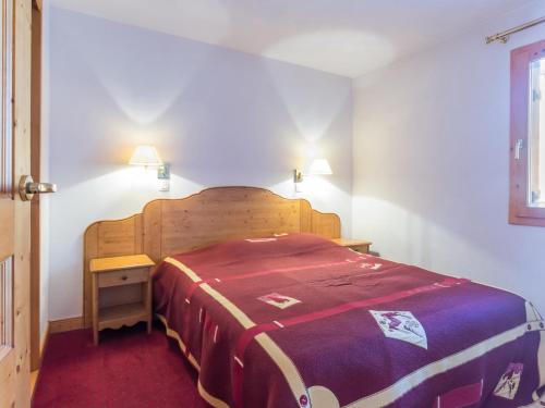 a bedroom with a bed with a wooden head board at Appartement Plagne Villages, 3 pièces, 6 personnes - FR-1-181-2625 in La Plagne Tarentaise