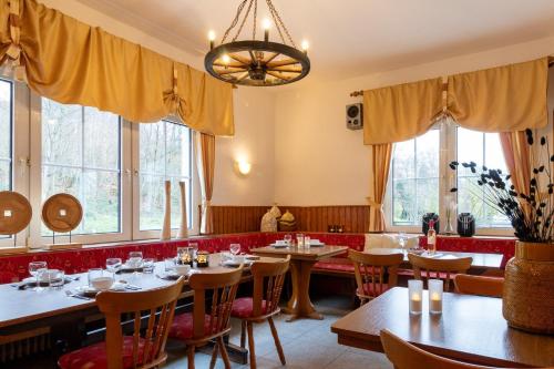 un restaurant avec des tables, des chaises et des fenêtres dans l'établissement Groepshuis Waldfrieden, à Medebach