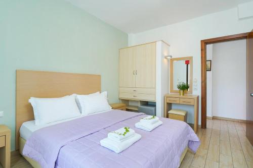 a bedroom with a purple bed with two towels on it at Thassos ESPERIA HOTEL in Pefkari