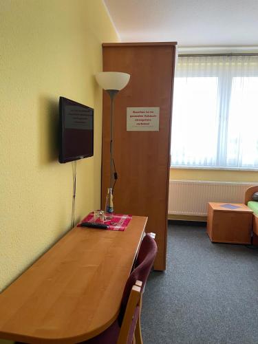 a conference room with a wooden table and a television at Pension Leyerhof in Wendisch Baggendorf