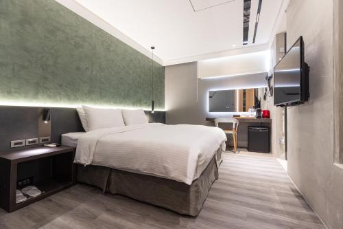 a bedroom with a bed and a flat screen tv at Green Hotel in Magong