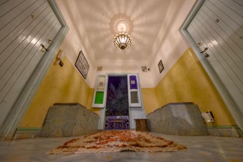 a hallway with a purple door and a rug on the floor at Maison d'hôtes Dar Farhana in Ouarzazate