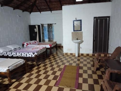 a room with three beds and a checkered floor at Nature Valley Homestay Near Annapoorneshwari Temple in Kalasa
