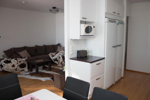 a living room with a couch and a microwave at Deluxe Apartment with Lake View and Sauna, Lahti in Lahti