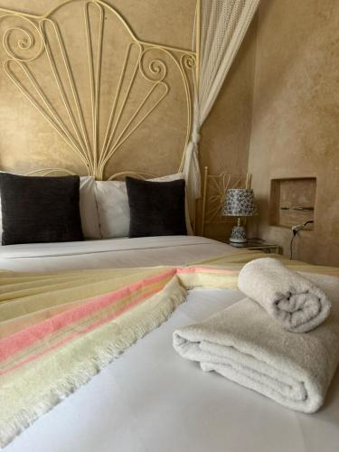 a bedroom with a large bed with towels on it at Dar Halima in Essaouira
