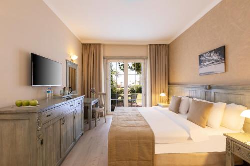 a hotel room with a large bed and a television at Alaçatı Beach Resort in Yumru
