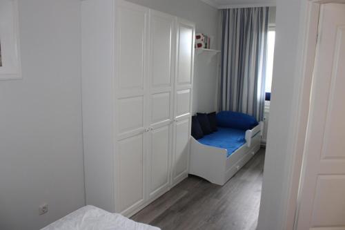 a small white bedroom with a blue bed in it at Ferienwohnung Ostseeperle S152 in Brasilien