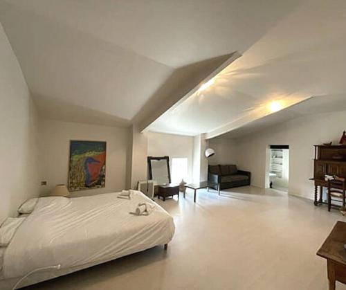 1 dormitorio con 1 cama blanca grande y piano en La commanderie Vue Panoramique 1 chambre en Le Poët-Laval