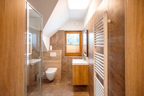 a bathroom with a toilet and a sink and a window at Chalupa U Myslivce in Dolní Lomná