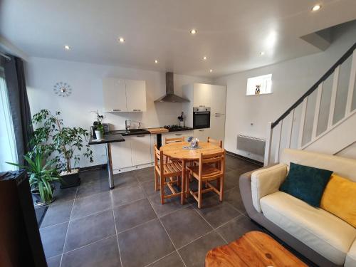 a kitchen and living room with a table and a couch at La Grange in Bretteville