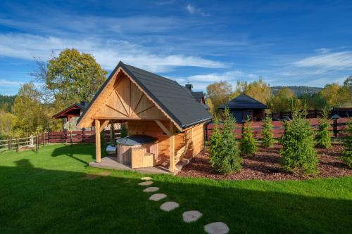 a gazebo with a grill in a garden at Willa Górski Raj - 4 sypialnie, 2 łazienki, sauna, tradycyjna balia in Korbielów