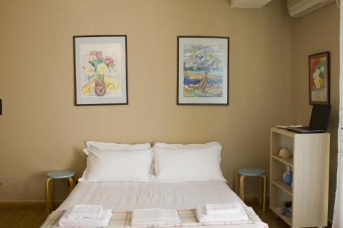 a bedroom with a bed with three pictures on the wall at Albi Guest House in Vlorë