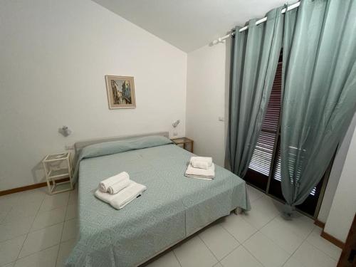 a bedroom with a bed with two towels on it at Residence Porto Coda Cavallo in San Teodoro