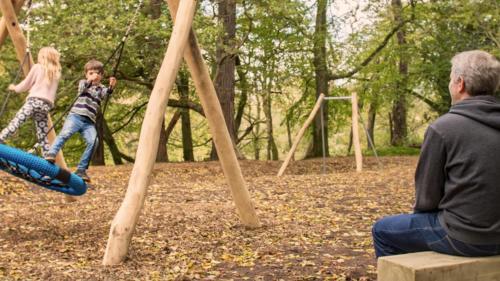 a man and a child playing on a swing set at Painters Cottage 2-Bed Chalet nr St Ives & Hayle in St Ives