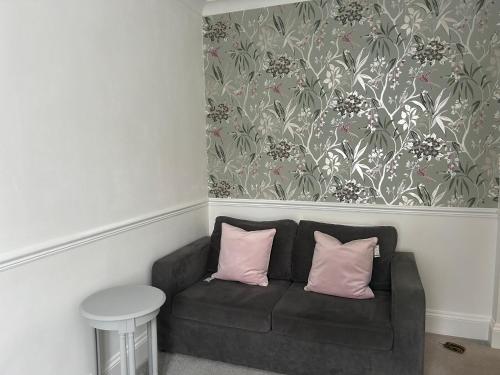 een bank met 2 roze kussens in een kamer bij The Millbrook B&B in Torquay