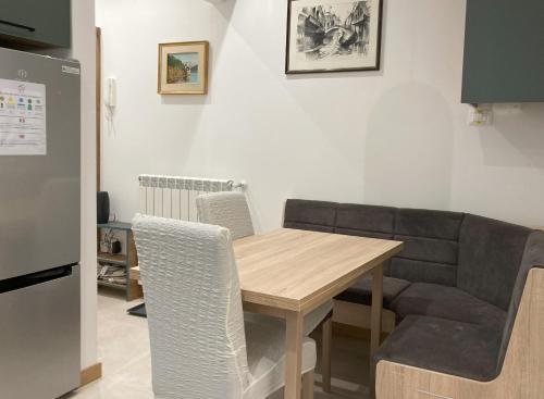 uma cozinha com uma mesa de madeira e um sofá em The Door em Trieste