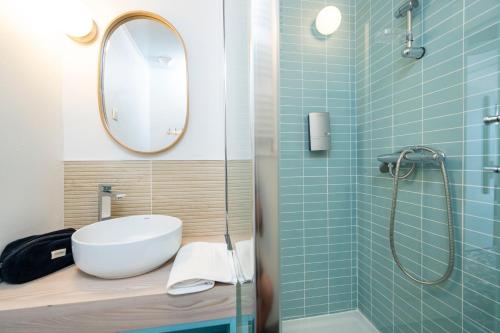 a bathroom with a sink and a shower with a mirror at Villages Clubs du Soleil - ORCIERES in Orcières