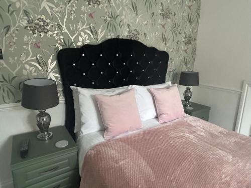 een slaapkamer met een bed en twee nachtkastjes met lampen bij The Millbrook B&B in Torquay