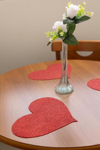 a vase of flowers on a table with red mats at Tezla Hotel in Primavera do Leste
