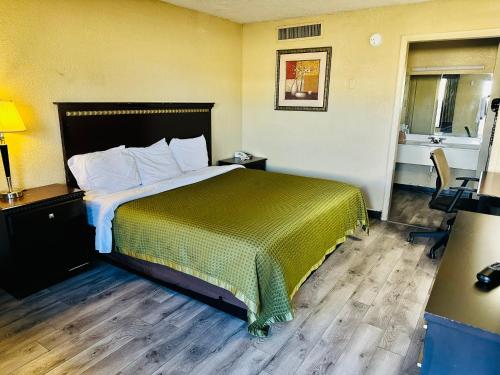 a hotel room with a bed with a green bedspread at Travel Inn Bristol near State Street in Bristol