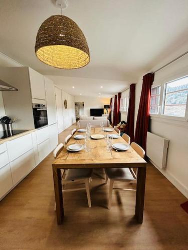 une table de salle à manger avec des chaises et une cuisine dans l'établissement NEW : Appartement Vue montagne, à Mont-Dore