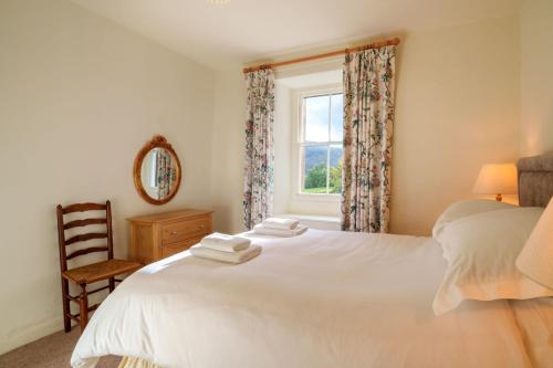 a bedroom with a white bed and a window at Townend Farmhouse - Ullswater in Watermillock