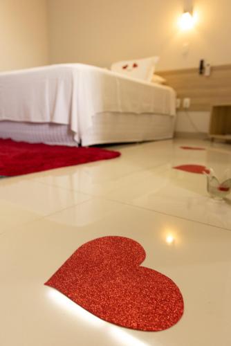 a red heart on the floor of a bedroom at Tezla Hotel in Primavera do Leste