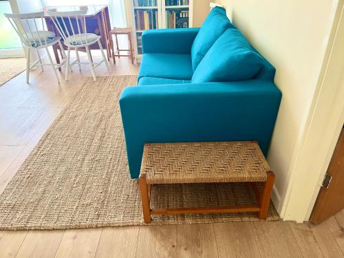 a blue couch and a table in a living room at Spacious garden 2 bed, sleeps 5 in Oxford