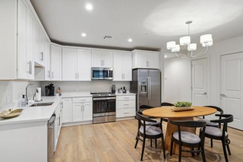 a kitchen with white cabinets and a table and chairs at The Eleanor New Orleans in New Orleans