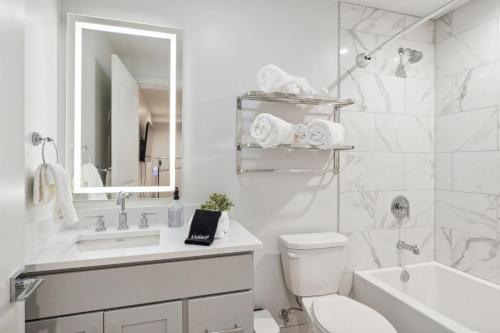 a bathroom with a sink and a toilet and a tub at The Eleanor New Orleans in New Orleans