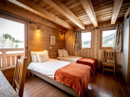 two beds in a room with wooden walls and windows at Appartement Plagne 1800, 6 pièces, 11 personnes - FR-1-181-2792 in La Plagne Tarentaise