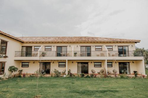 an exterior view of a building with a yard at Pietra Hotel in Sáchica