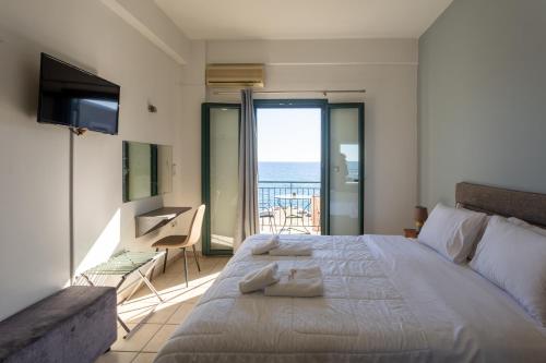 sypialnia z łóżkiem i widokiem na ocean w obiekcie Marina w mieście Kardamyli