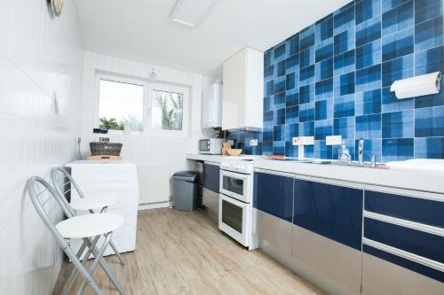 uma cozinha azul e branca com um balcão e um lavatório em GuestReady - Spacious 2BR Flat in Peaceful Hove em Brighton & Hove