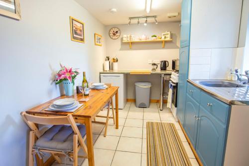 a kitchen with a wooden table and a sink at Crofters Retreat 