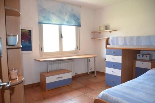 Schlafzimmer mit einem Bett, einem Schreibtisch und einem Fenster in der Unterkunft Preciosa Casa tranquila rodeada de naturaleza in Piera