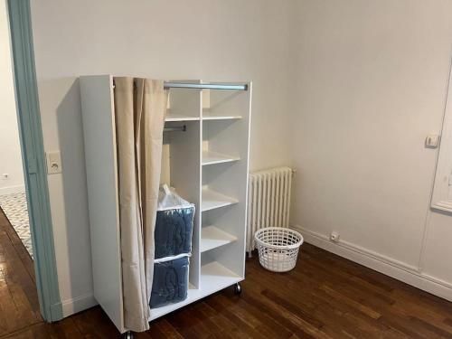 a white cabinet in a room with wooden floors at Appartement cœur de ville in Soissons