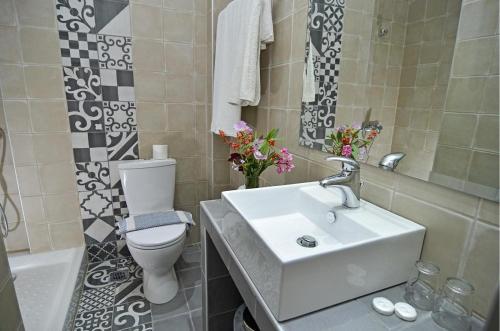 a bathroom with a white sink and a toilet at Thassos ESPERIA HOTEL in Pefkari