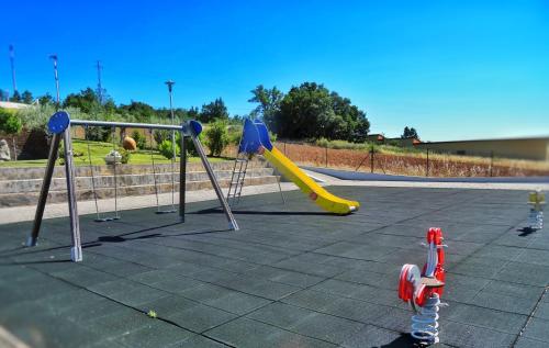 a playground with two swings and a slide at Hotel Estalagem Turismo in Bragança