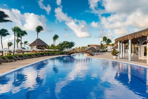 a swimming pool at a resort with palm trees at Ocean Maya Royale Adults Only - All Inclusive in Playa del Carmen