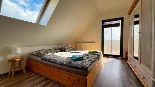 een bed in een kamer met een groot raam bij Ferienhaus Zum Findling in Göhren