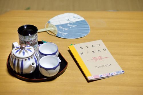 a table with a tray of china and a book at Stay Nikko Guesthouse in Nikko