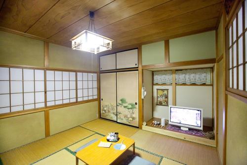 a room with a table and a tv in it at Stay Nikko Guesthouse in Nikko
