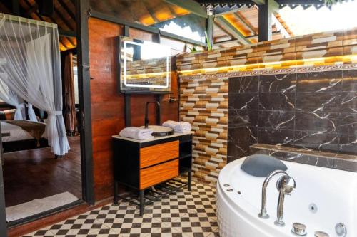 Un baño con bañera, ducha y lavabo. en Villa Lalupa Joglo, en Canggu